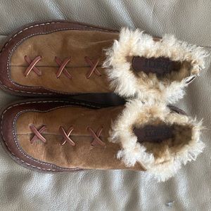 Born suede and leather slip on shoes with simulated fur inside.